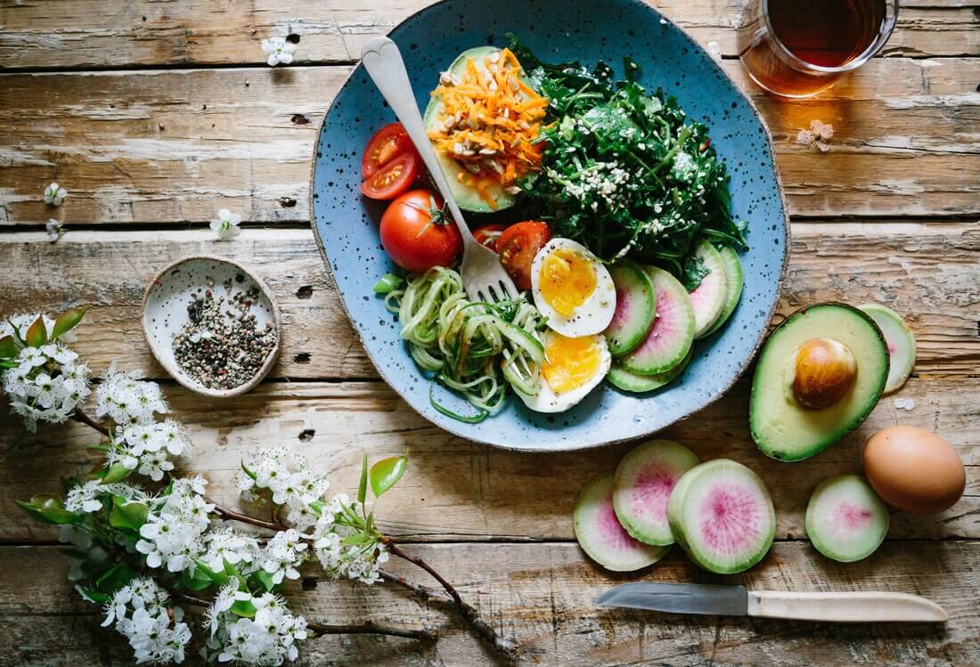 Poached egg and veggie bowl on wood table