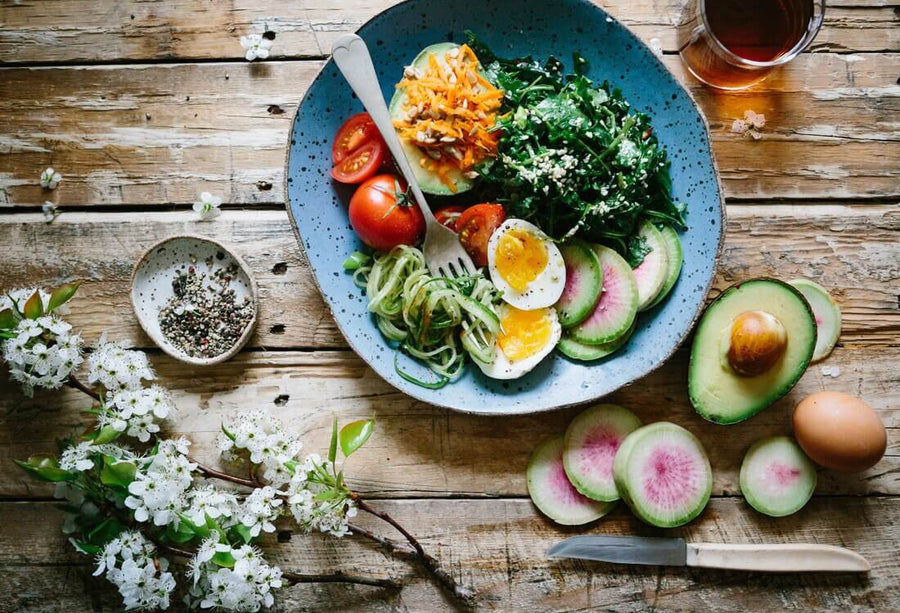 Poached egg and veggie bowl on wood table